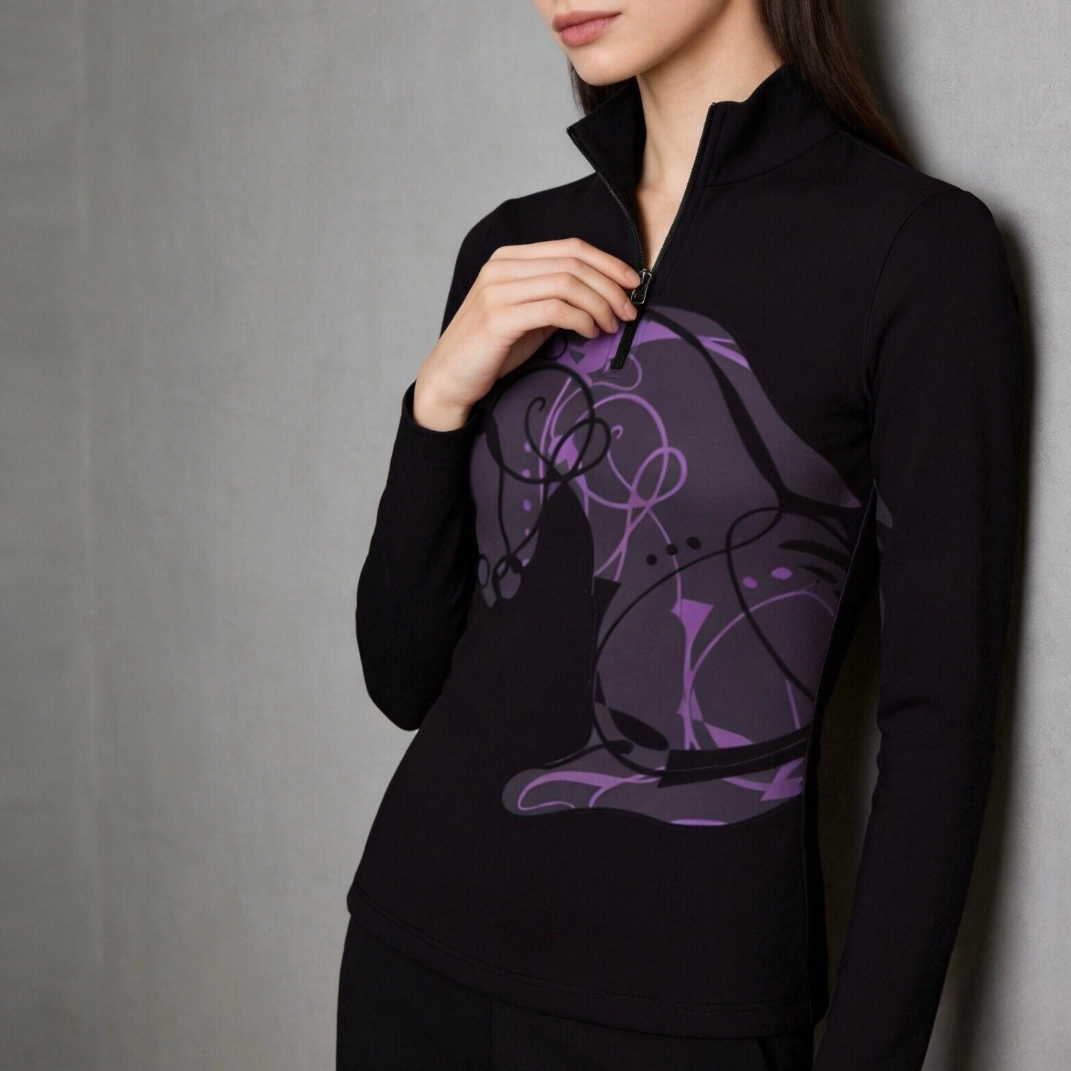 Soft grey interior wall shot focusing on zipper and front abstract purple horse graphic on black long sleeve quarter-zip riding top