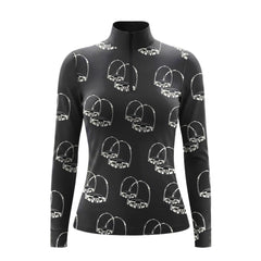 Model standing beside brown horse’s head wearing monochrome sketch stirrup hardware long sleeve riding top against light grey stable wall
