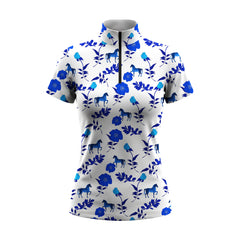 White background studio shot of off-white bright blue floral mini horse silhouette allover print short sleeve quarter zip riding top