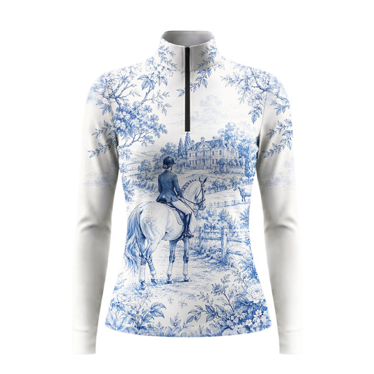 White background studio shot of soft off-white blue French toile manor rider landscape allover print long sleeve quarter zip riding top
