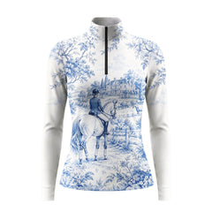 White background studio shot of soft off-white blue French toile manor rider landscape allover print long sleeve quarter zip riding top
