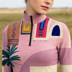 Soft golden countryside grass field close-up shot focusing on stand collar, black half-zip and front boho Mediterranean palm tree geometric abstract print riding top
