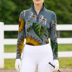 Full-body model shot wearing cheerful boho carousel horse sunflower equestrian riding top at sunlit green pasture white wooden fence