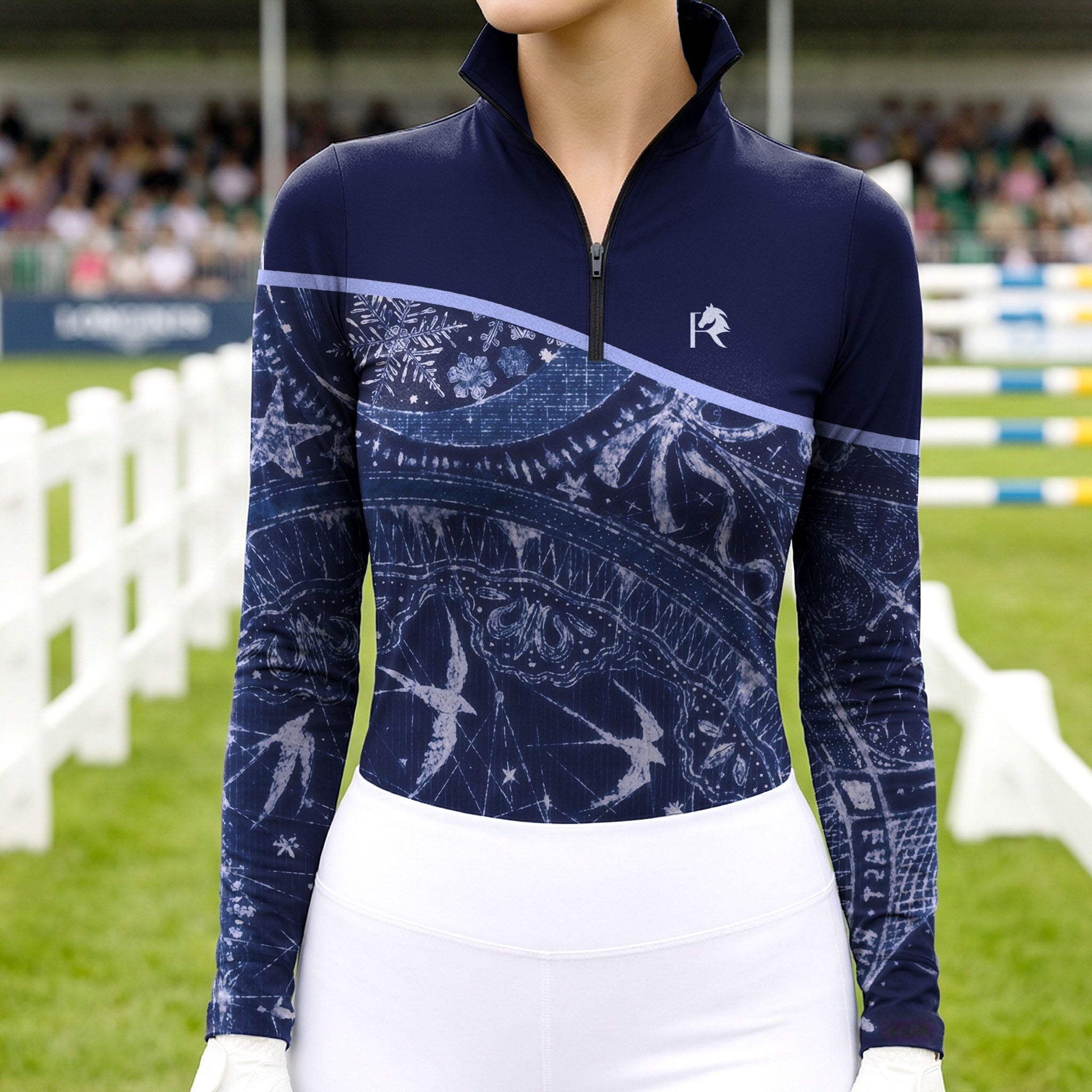 Model wearing the Celestial Night Print Color-Block Riding Top at a competition arena, with jumps in the background
