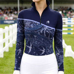 Model wearing the Celestial Night Print Color-Block Riding Top at a competition arena, with jumps in the background
