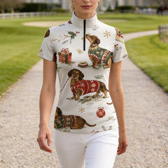 Outdoor gravel path shot of female rider wearing cream vintage Christmas dachshund holiday print short‑sleeve riding top