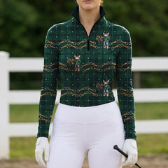 Outdoor white‑fence model shot of female equestrian wearing dark green tartan long‑sleeve riding top with cowboy cat, pony and horse‑bit all‑over print
