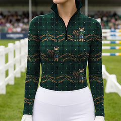 Showground arena model shot of rider in dark green tartan quarter‑zip long‑sleeve riding top featuring playful cowboy cat‑pony horse‑bit print