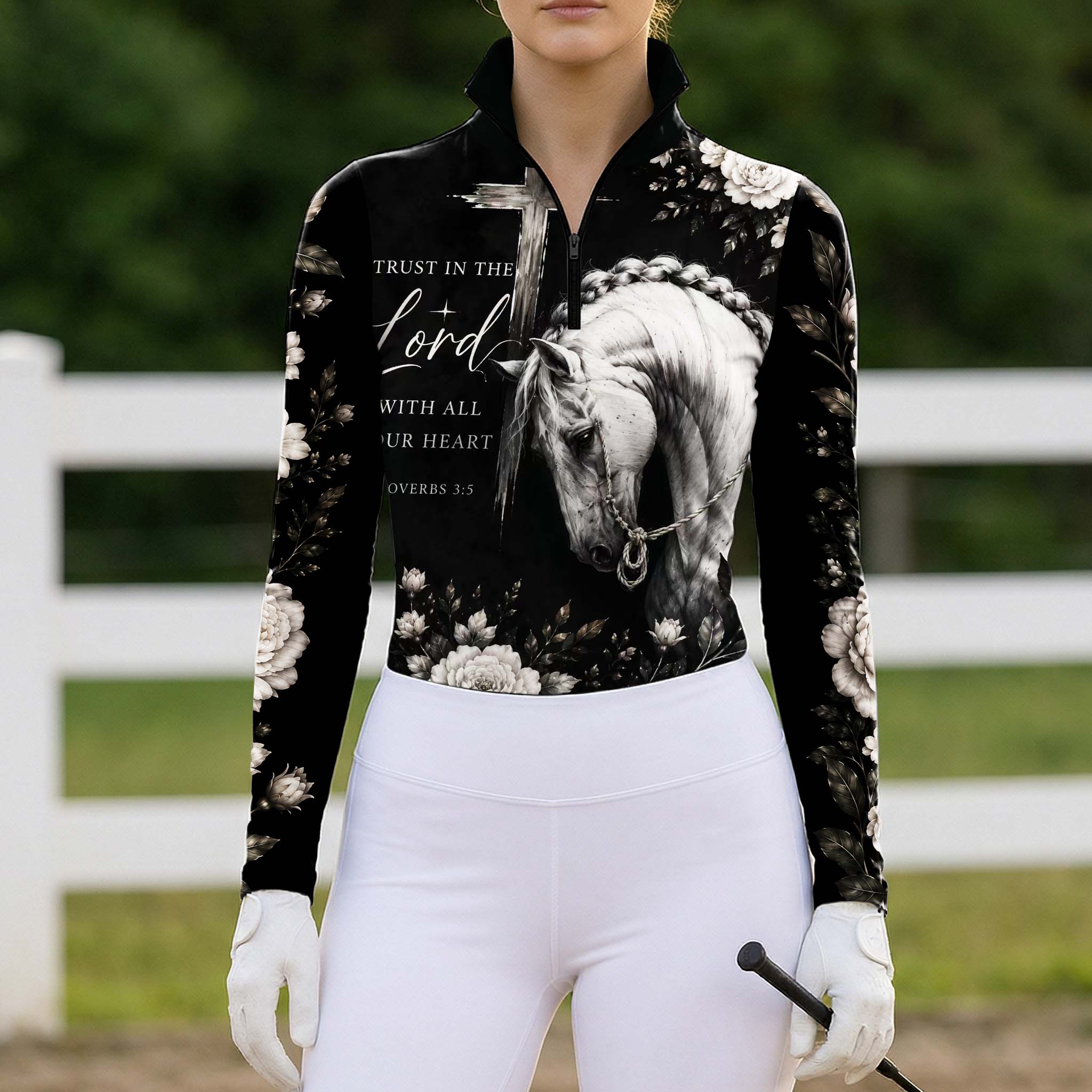 Full-body model shot wearing rustic faith equestrian long sleeve top at sunlit green pasture white wooden fence, holding riding crop
