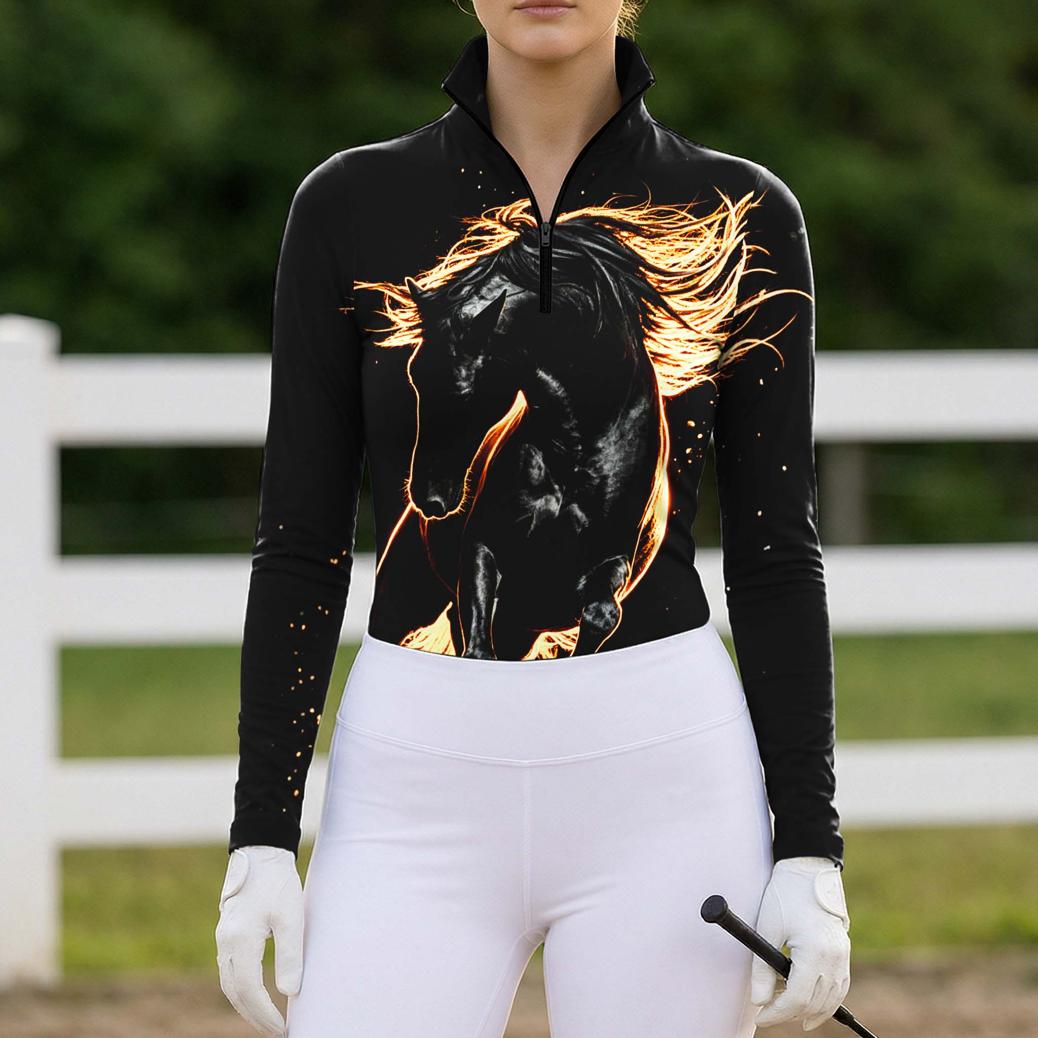 Full-body model shot wearing dramatic wild fiery horse long sleeve top at sunlit green pasture white wooden fence, holding riding crop
