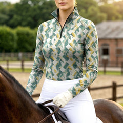 Woman wearing forest textured diamond horse silhouette equestrian quarter-zip top in moss and gold, riding a chestnut horse at the equestrian stable
