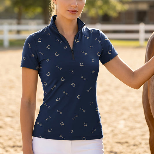 Model wearing navy gold line tack riding top beside brown horse on sunlit dirt pasture