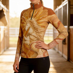 Sunlit equestrian stable walkway shot of model posing wearing warm golden amber sunburst white unicorn art print long sleeve quarter-zip riding top