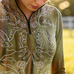 Sunlit outdoor close-up detail shot showcasing delicate symmetrical pegasus rose vine line art print on gradient olive equestrian top
