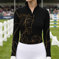 Equestrian show arena close‑up shot of rider wearing black gold horse‑retriever graphic long‑sleeve riding top with white breeches and riding gloves