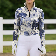 Full-body model portrait wearing artistic sketch horse print riding apparel beside white pasture fencing holding a riding crop

