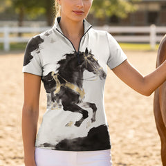 Model wearing bold artistic ink steed print riding top beside a brown horse at sunlit dirt riding arena