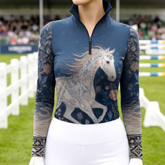 Model wearing dark botanical horse print riding top at outdoor fenced equestrian show arena with jump obstacles