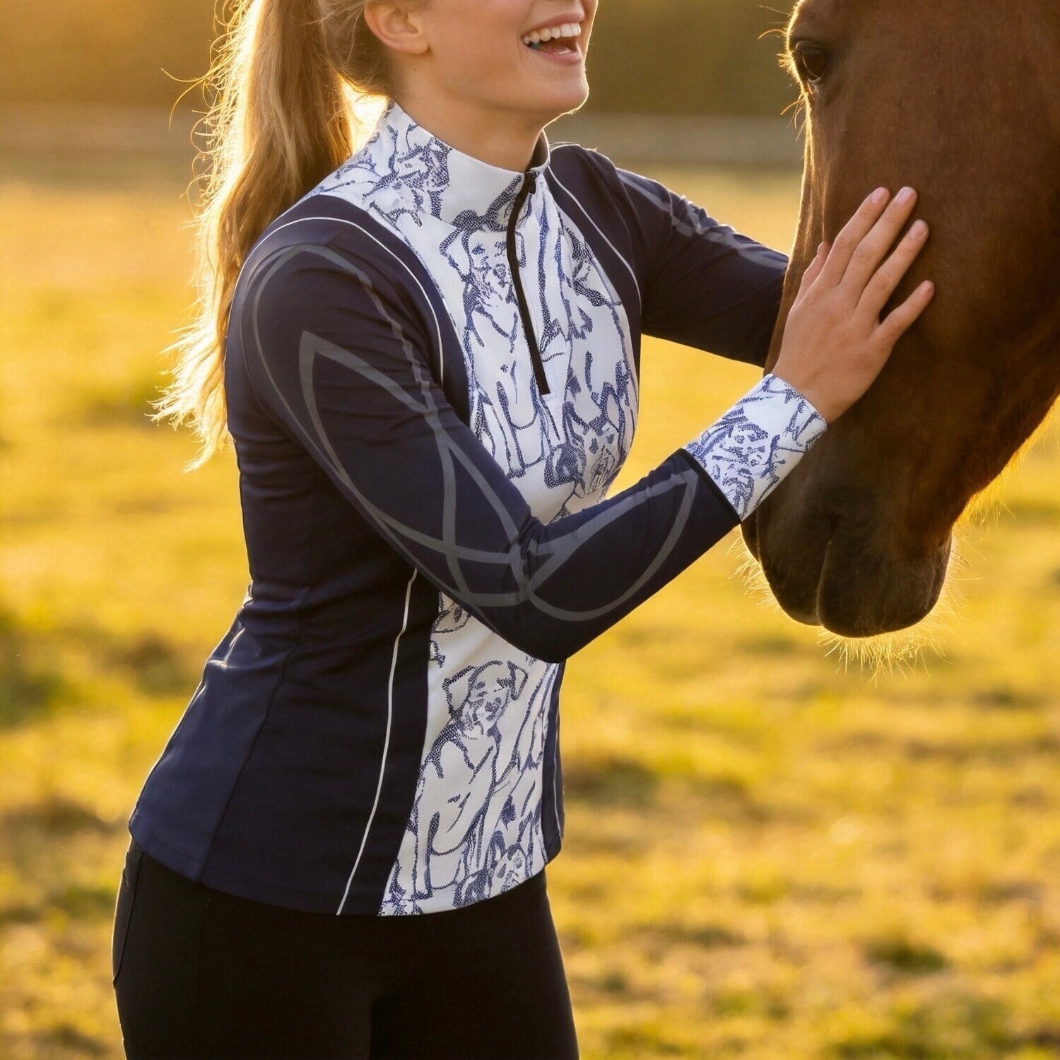 Golden hour countryside field side profile photo of model wearing dog print riding top beside horse