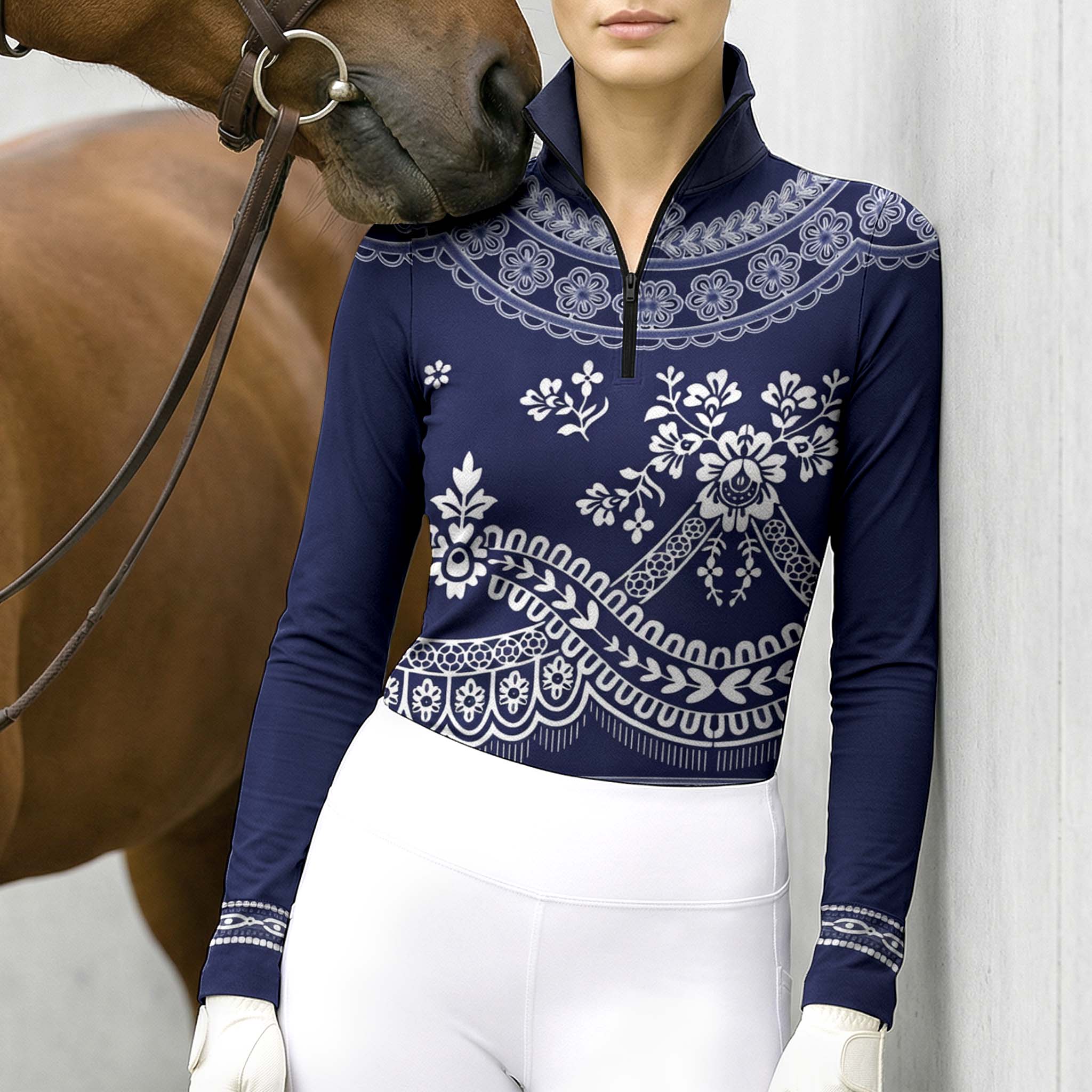 Model wearing navy vintage lace horse riding top leaning beside chestnut horse at stable
