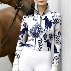 Model standing beside a chestnut horse against light grey stable wall wearing off-white navy forest wolf fox long sleeve riding top