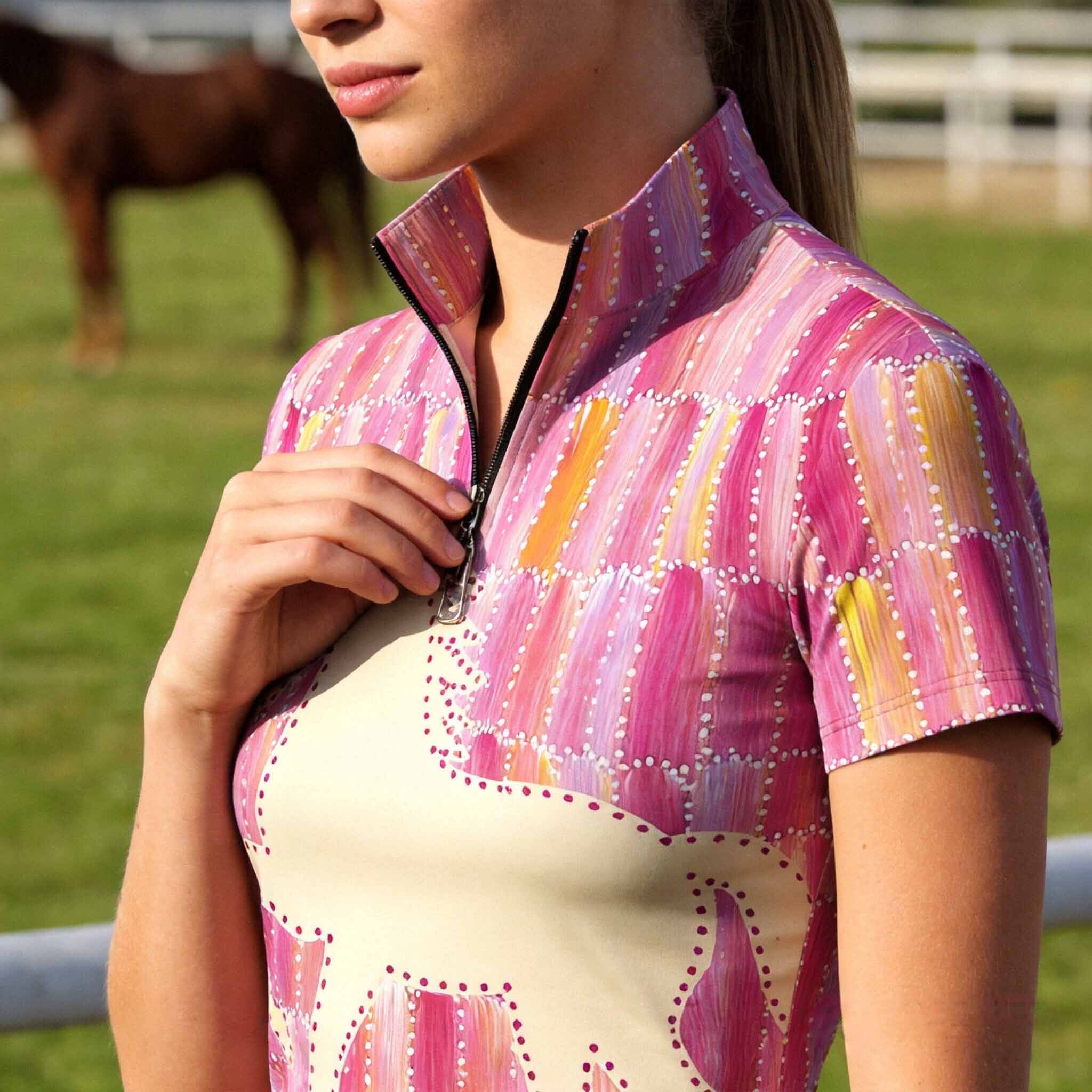 Clean white background studio product shot of pink patchwork galloping horse silhouette short sleeve riding top
