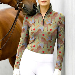Woman wearing RIDER ATELIER cute cartoon horse sage green quarter-zip top with a chestnut horse