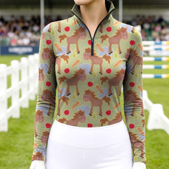 Woman wearing RIDER ATELIER cute cartoon horse sage green quarter-zip top at the show jumping arena