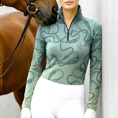 Woman wearing RIDER ATELIER teal gradient equestrian tack quarter-zip top with a chestnut horse