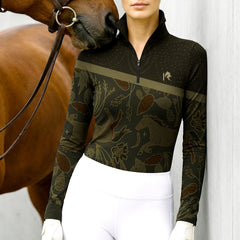 Woman wearing RIDER ATELIER folk art quarter-zip top with a chestnut horse
