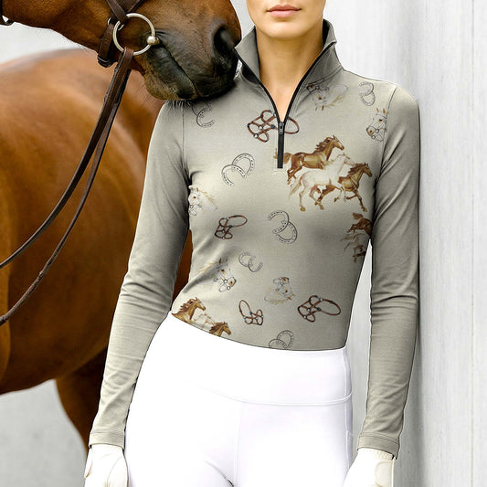 Woman wearing RIDER ATELIER galloping horse & horseshoe long sleeve quarter-zip top with a chestnut horse
