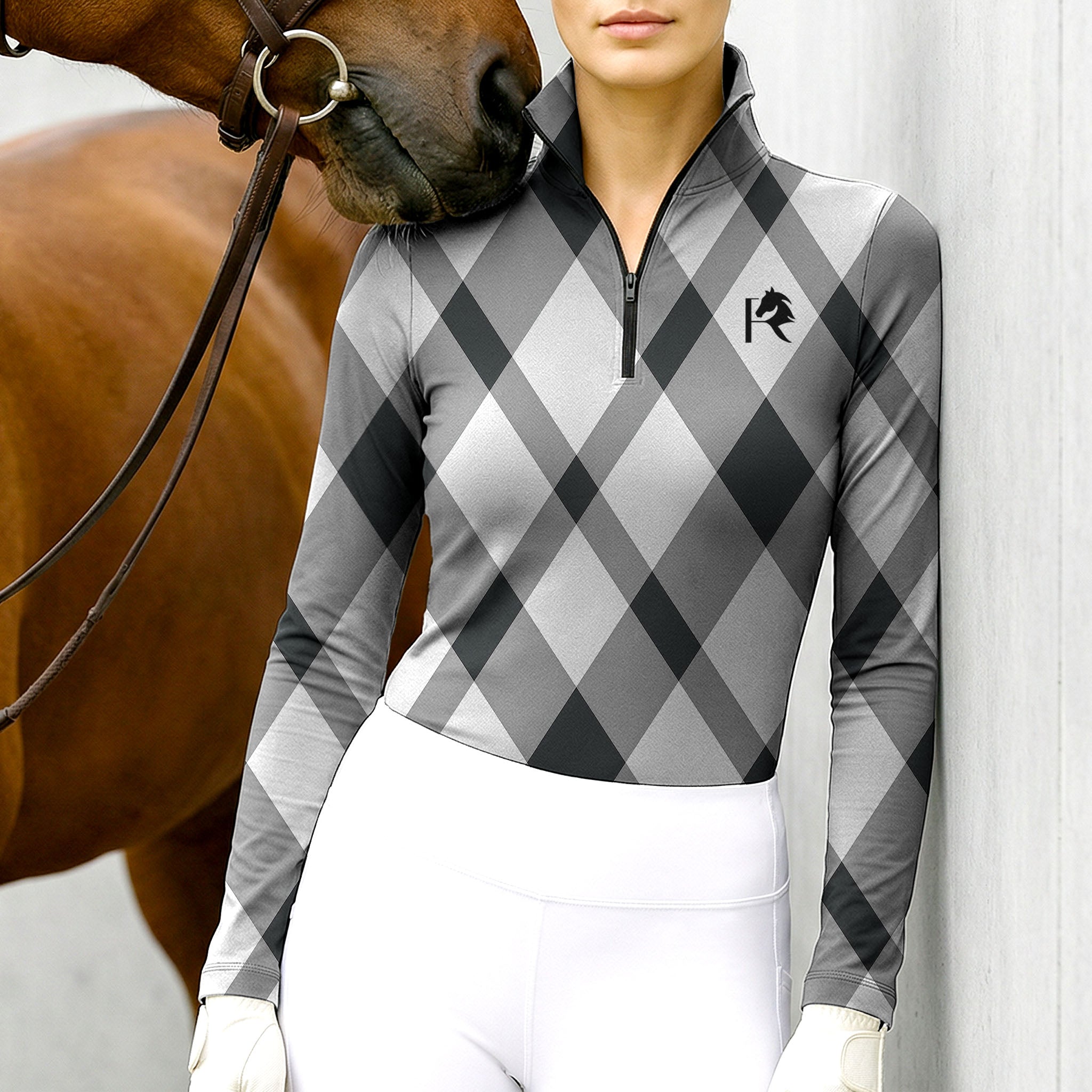 Woman wearing RIDER ATELIER gray argyle quarter-zip top with a chestnut horse