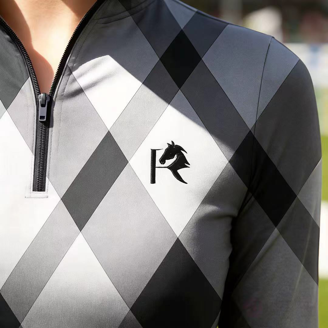 Close-up of RIDER ATELIER gray argyle quarter-zip top showing horse head logo and zipper