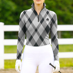 Woman wearing RIDER ATELIER gray argyle quarter-zip top at the outdoor pasture