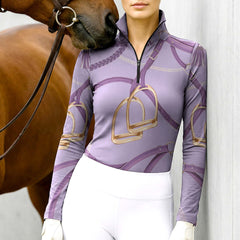 Woman wearing RIDER ATELIER lavender stirrup & bridle lilac quarter-zip top at the barn with a chestnut horse
