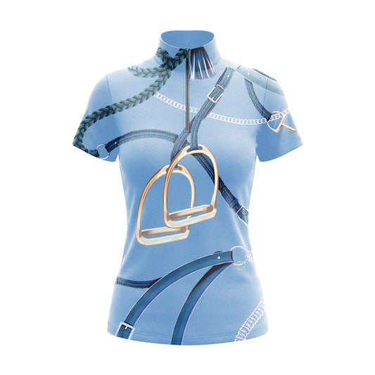 Studio shot of the RIDER ATELIER Light Blue Equestrian Tack Print Short-Sleeve Quarter-Zip Riding Top, showing full stirrup, rein, and chain print pattern, quarter-zip collar, and fabric texture against a clean white background
