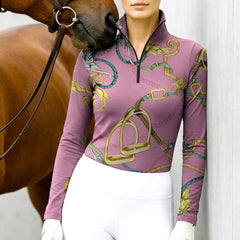 Woman wearing RIDER ATELIER luxury baroque horse tack pink quarter-zip top with a chestnut horse