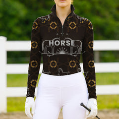 Woman wearing RIDER ATELIER luxury horse motif quarter-zip top at the outdoor pasture
