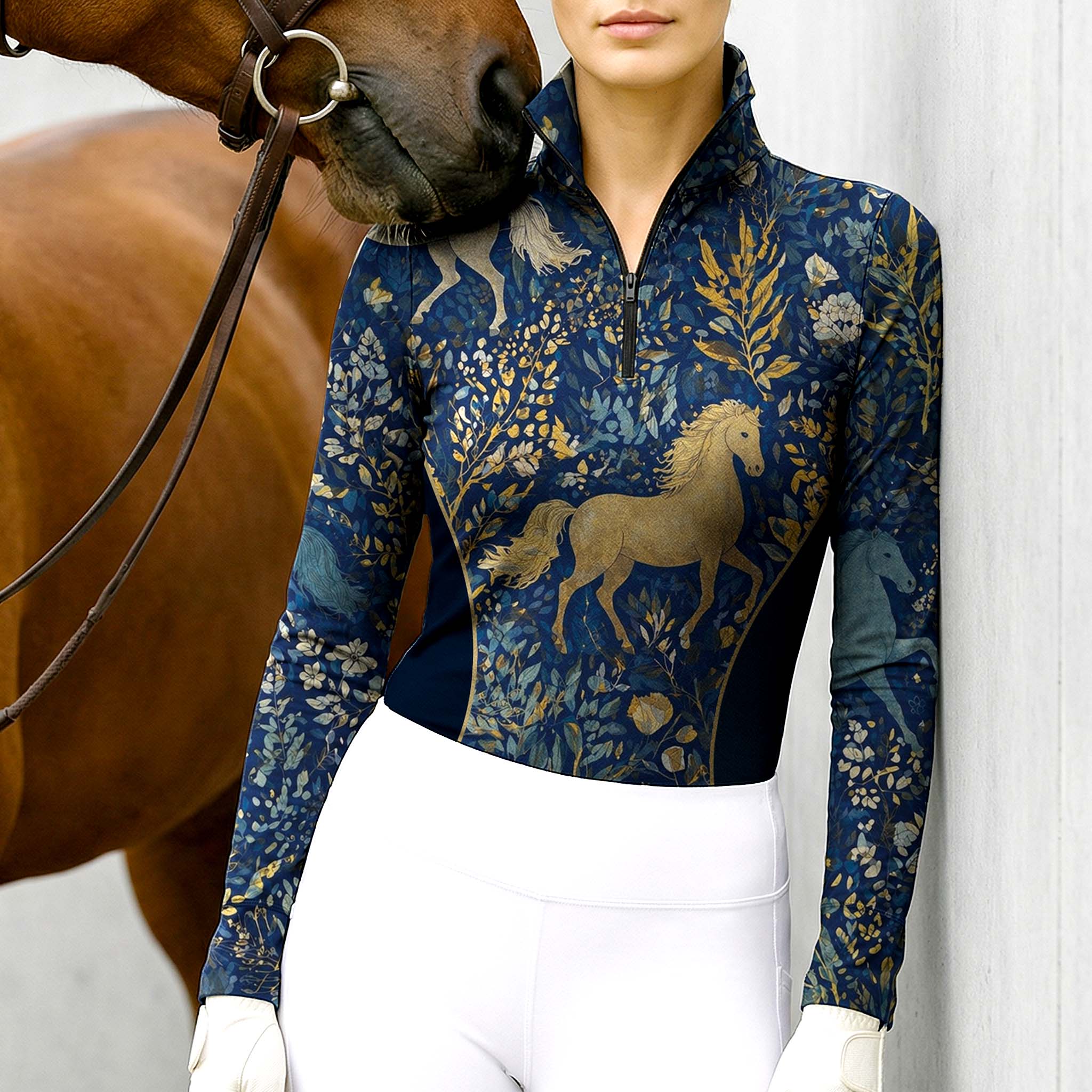 Model wearing the RIDER ATELIER Midnight Blue Mythical Horse & Floral Riding Top at the stable, with a chestnut horse, highlighting the print’s magical texture
