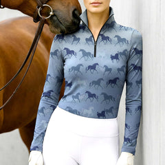Woman wearing RIDER ATELIER ombre multi horse silhouette light blue quarter-zip top at the barn with a chestnut horse