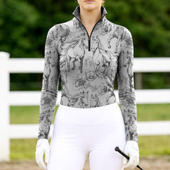 Woman wearing RIDER ATELIER sketch horse floral light gray quarter-zip top at the show jumping arena