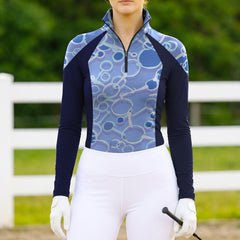 Woman wearing RIDER ATELIER snaffle bit color block quarter-zip top at the outdoor pasture