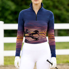 Woman wearing RIDER ATELIER sunset horse silhouette navy quarter-zip top at the outdoor pasture