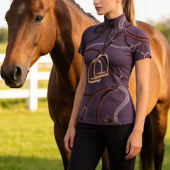 Woman in equestrian attire standing next to a horse in a field