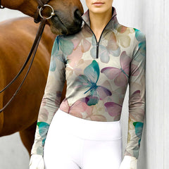 Woman wearing RIDER ATELIER watercolor butterfly beige quarter-zip top with a chestnut horse