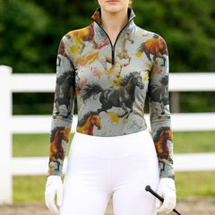 Woman wearing RIDER ATELIER watercolor galloping herd quarter-zip top at the show jumping arena