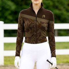 Woman wearing RIDER ATELIER western botanical horse brown quarter-zip top at the outdoor pasture