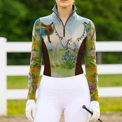 Woman wearing RIDER ATELIER whimsical horse and floral quarter-zip top at the outdoor pasture