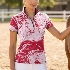 Full-body model shot wearing modern bold sketch horse short sleeve top at outdoor equestrian show jumping arena with spectator stands, holding riding crop
