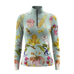 Model leaning against light grey stable wall beside chestnut horse wearing sage vintage tropical flower butterfly riding top

